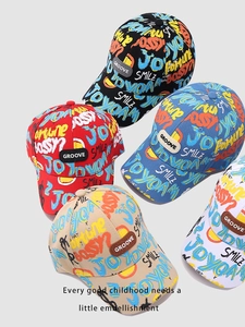 Détail des imprimés graffiti colorés et des étiquettes en cuir sur les casquettes enfant