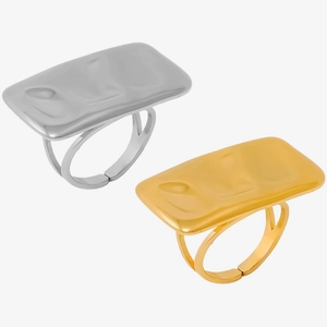 Macro detail of gold and silver rectangular rings with wavy texture and double band