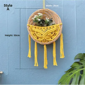 Detail eines gewebten Wandkorbs aus Rattan mit gelbem Schmetterlingsdesign und Fransen