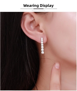 Close-up of Moissanite tassel earrings with six round-cut stones on a model
