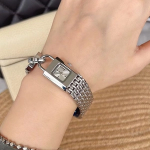 Detail of silver square padlock watch with metal mesh strap on a model wrist