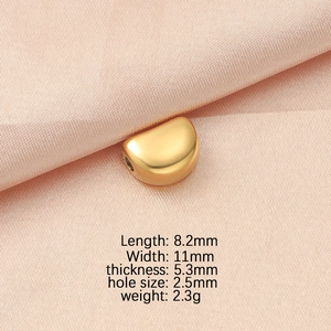 Detailed view of gold crescent bead showing 8.2x11mm dimensions on pink silk fabric