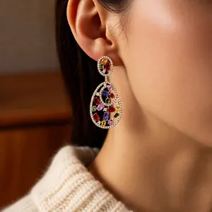 Vintage gold oval earrings with multicolor zircons and micro-set crystals worn by a model