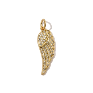 Detailed close-up of a golden angel wing pendant with pavé set white cubic zirconia