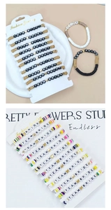 Close-up of Team Bride colorful clay bead bracelets with gold heart accents