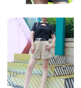 Detailed view of trendy black leather belt with silver buckle on khaki shorts