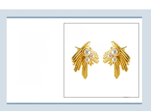 Macro detail of 18K gold plated stainless steel swallow earrings with white pearls