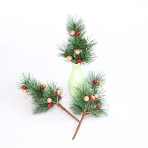 Mini branches de Noël avec baies rouges et pommes de pin dans un vase en céramique