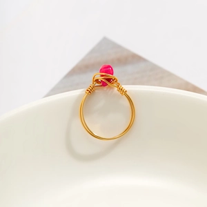Detail of handcrafted gold wire wrapped ring with a pink teardrop gemstone accent