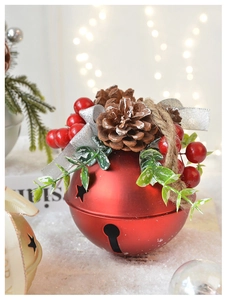 Macro shot of large red Christmas bell with natural pine cones and festive berries