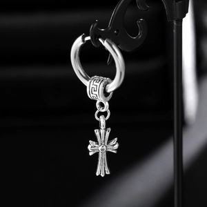 Detail shot of silver gothic cross earring with ornate engraving on a black stand