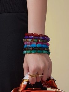 Detailed close-up of multi-layer colorful natural stone beaded bracelets on model wrist