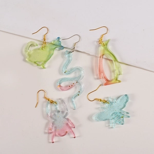 Detailed view of glittery animal-shaped acrylic charms in pastel gradient colors