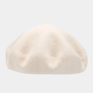 Detail view of a cream-colored wool beret featuring a soft texture and classic top stem