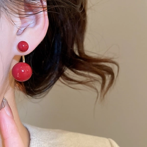 Dettaglio degli orecchini a C placcati oro 14k con sfere rosse e finitura lucida