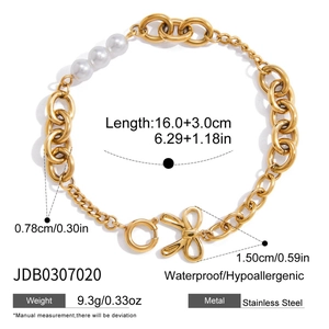 Détail d'un bracelet chaîne doré avec trois perles d'imitation et fermoir nœud