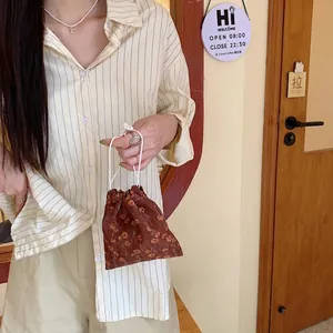 Primer plano de bolsa de pana con flores vintage y cordones de algodón blanco