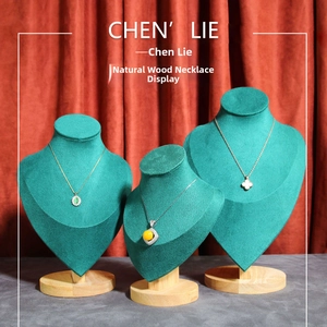 Three-piece bust necklace display set with green velvet surface and wood base