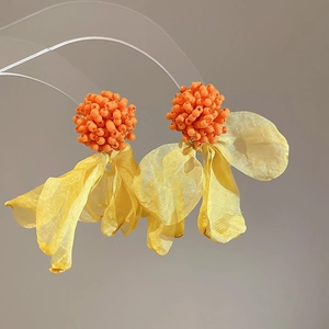 Detailed macro view of orange beaded clusters and yellow chiffon fabric flower petals