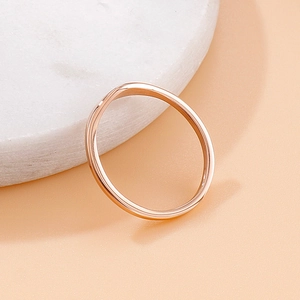 Polished rose gold wave ring for men and women on white marble stone base