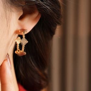 Detail view of 18k gold plated flower stud earrings with zircon on model ear