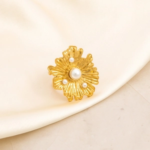 Detail of 18K gold plated stainless steel ring with petals and centered pearls on silk