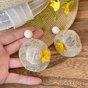 Detailed straw woven earring featuring mini sun hat design with yellow flower