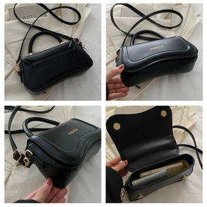Detail view of black matte leather crossbody bag with gold hardware and fashion embossing