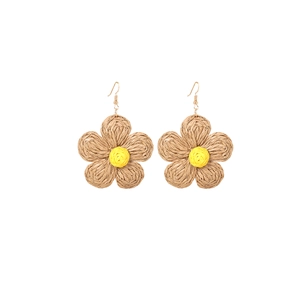 Detailed shot of handmade raffia flower earrings with brown petals and yellow center