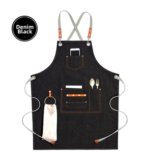 Detail of black denim apron with multi-functional pockets and leather decorative accents