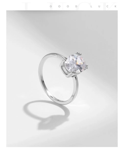 Detailed macro view of the silver four-claw setting with a brilliant round-cut zircon stone