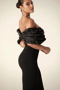 Detail of elegant off-shoulder evening dress featuring dramatic pleated puff sleeves in black