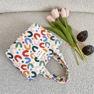 Détail d'un sac cabas matelassé en coton avec motif en U coloré et étiquette en tissu