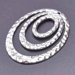 Detailed view of silver oval pendant with hammer-textured finish and concentric oval design