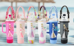 Detailed row of tumblers with handmade woven straw covers and clover tassel charms