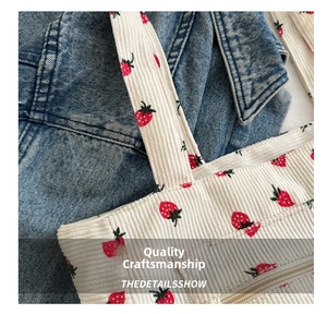 Close-up of strawberry print corduroy tote bag showing metal zipper detail and texture