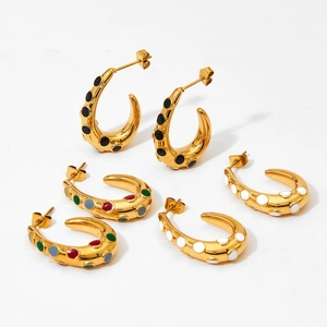 Three pairs of gold C-shaped hoop earrings with colorful dotted enamel on white background