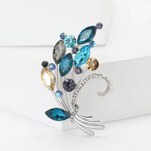 Macro detail of bouquet brooch featuring colorful rhinestones and silver metal finish