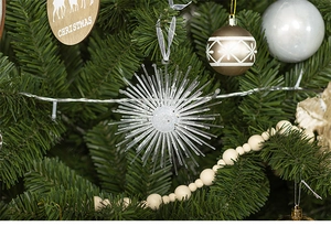 Detail of sparkling star Christmas ornament with glitter finish on a festive tree