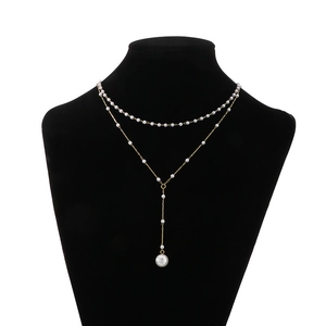 Elegant double-layered Y-shaped gold pearl necklace with tassel pendant on neck mannequin