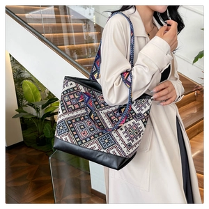 Detailed shot of ethnic geometric woven tote bag with durable black leather base and strap