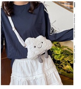 Detail of cute white cloud plush crossbody bag with smiling face and adjustable strap