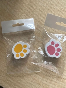 Detail view of pink and yellow cat claw cleaning sponges in hanging packaging