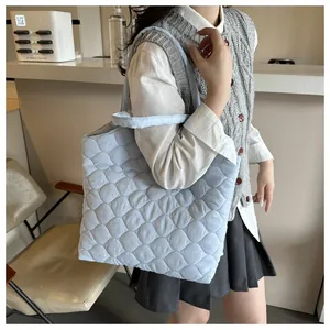 Close-up of light blue quilted tote bag showing intricate stitching and soft texture