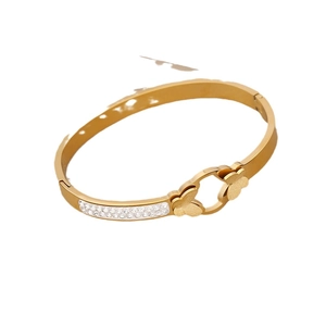 Golden flower bangle with sparkling rhinestones and white shell petals on white background