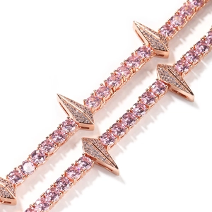 Macro view of rose gold tennis chain featuring pink round zircons and triangular diamond spikes