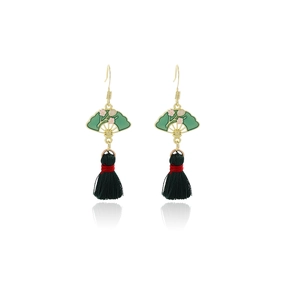 Macro shot of green fan-shaped enamel earrings with silk tassels and floral details
