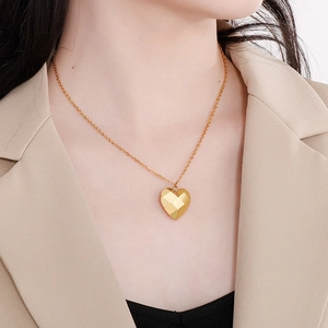 Vue détaillée du collier coeur creux plaqué or 18K avec facettes géométriques sur mannequin
