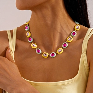 Close-up of a colorful vintage geometric necklace with pink and lilac gemstones on model