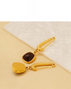 Detail of 18K gold plated safety pin earrings featuring a brown cabochon stone